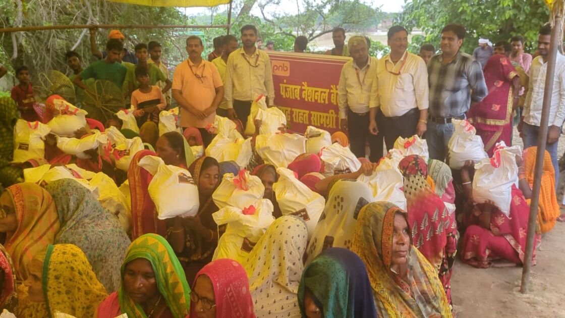 पीएनबी बलिया शाखा द्वारा बाढ़ पीड़ितों को राहत सामग्री वितरित करते अधिकारी