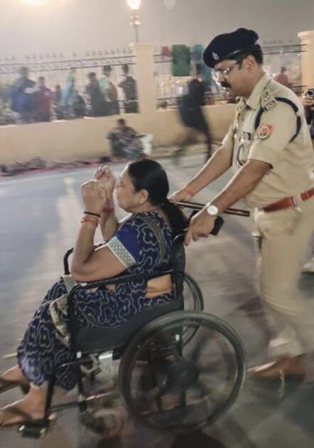 एसपी ग्रामीण बलवंत चौधरी बुजुर्ग महिला को व्हीलचेयर से मार्ग पार कराते हुए